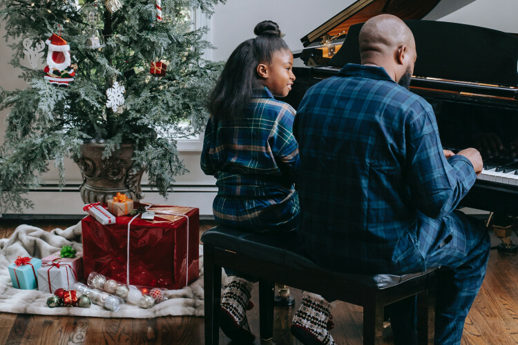 father and daughter playing the piano together